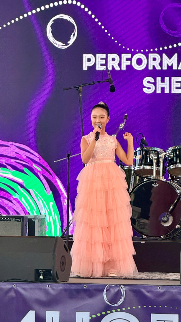 Speech and Drama student performing on stage in a formal gown