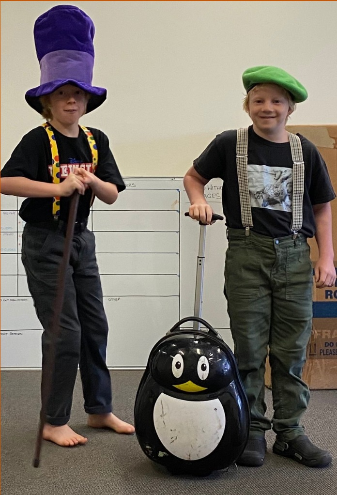 Two Speech and Drama students in eisteddfod costume, wearing a top hat and beret with a penguin prop